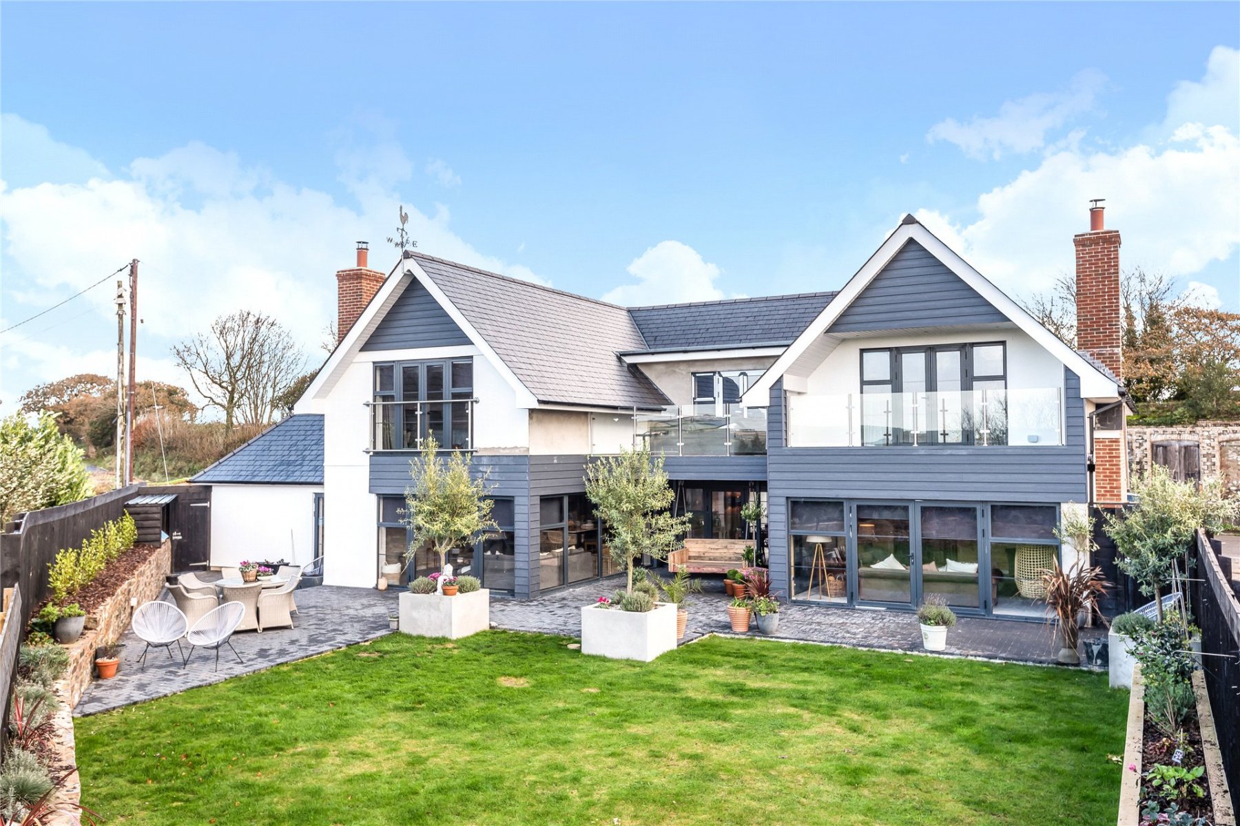 rear of the property with a Juliet balcony on one side and large balcony on the other. ground floor has lots of glazing and large bifold doors
