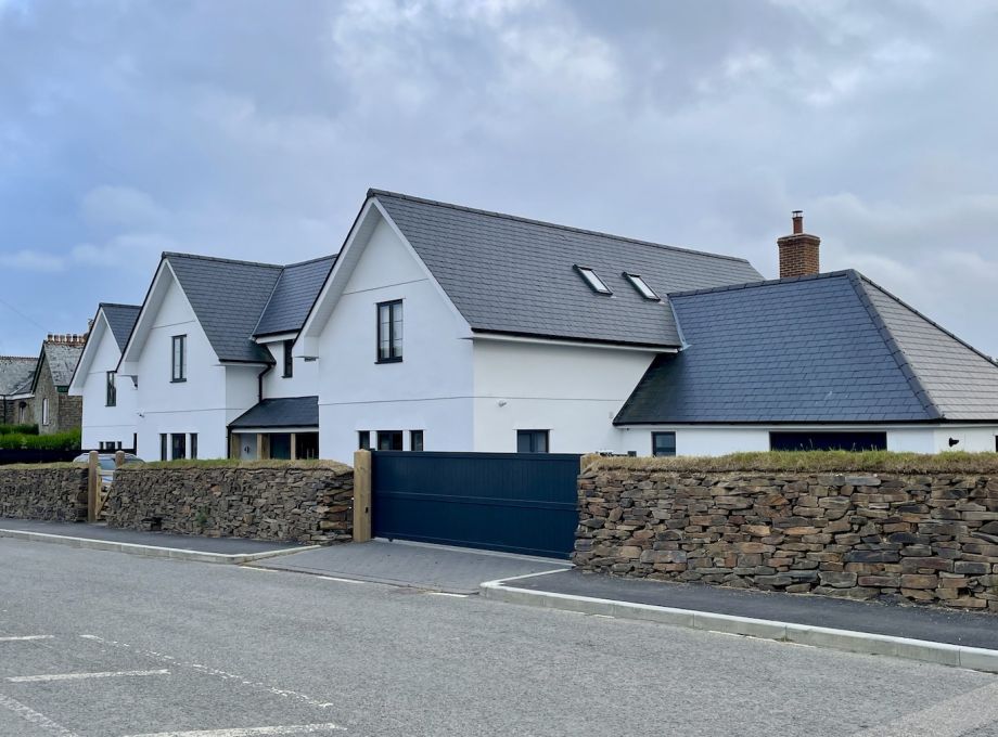 image from across the road of a large double frosted brew build with private gate and a second smaller new build with off street parking