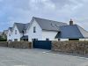 image from across the road of a large double frosted brew build with private gate and a second smaller new build with off street parking